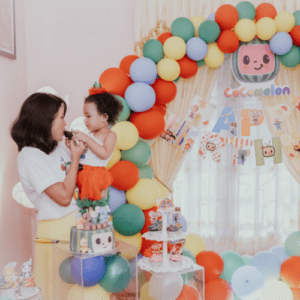 Enfant qui donne du gateau d'anniversaire à sa maman devant un joli décor